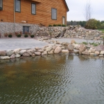Concrete patio, outdoor pond and stone retaining wall installed in Wisconsin